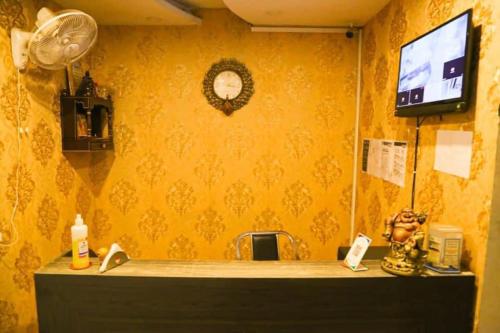 um quarto com uma parede amarela, uma secretária e uma televisão em Hotel royal orbit em Zirakpur
