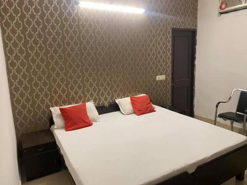 um quarto com uma cama grande e 2 almofadas vermelhas em Hotel royal orbit em Zirakpur