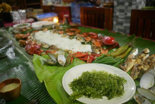 - une table avec une assiette de fruits de mer et de légumes dans l'établissement JMTヴィラ, à Dinalupihan