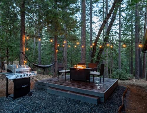 una terrazza in legno con tavolo e sedie nel bosco di Nature's Nook - Blissful Cabin in the Woods a Placerville