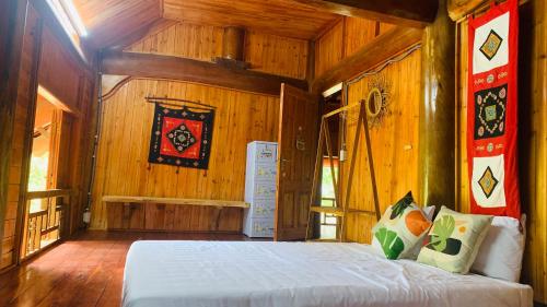 - une chambre avec un lit dans une pièce en bois dans l'établissement Pea homestay, à Sa Pa