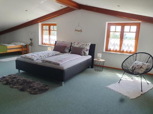 a bedroom with a bed and a chair in it at Ferienhaus Panorama in Rechnitz