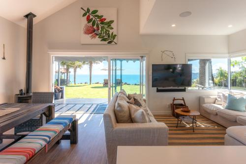Una sala de estar con un sofá y un televisor. en The Point - Stay Waiheke, en Onetangi