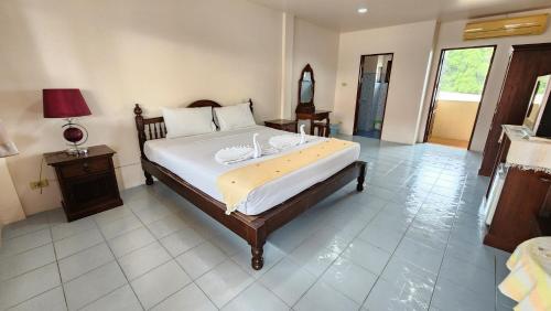 a bedroom with a large bed with white sheets at Panupong Hotel in Chaweng