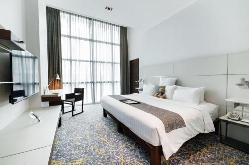a hotel room with a large bed and a desk at S31 Sukhumvit Hotel in Bangkok