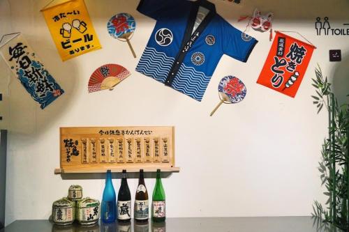 a wall with signs and wine bottles on it at Hibnb Guesthouse in Zhuangwei