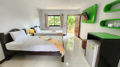 a bedroom with two beds and a television in it at Panupong Hotel in Chaweng