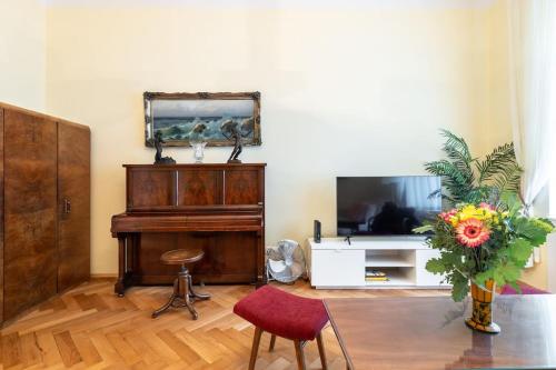 uma sala de estar com um piano e uma televisão em Historic Apartment em Praga