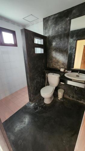 a bathroom with a toilet and a sink at Panupong Hotel in Chaweng
