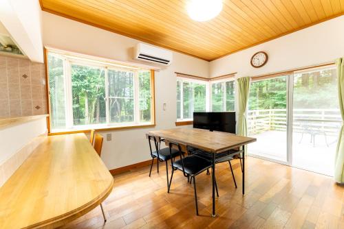 a dining room with a table and chairs at Green Oasis Cottage Hakone Sengokuhara - グリーンオアシスコテージ箱根仙石原 in Sengokuhara