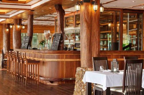 a restaurant with a bar with tables and chairs at Parama Koh Chang in Ko Chang