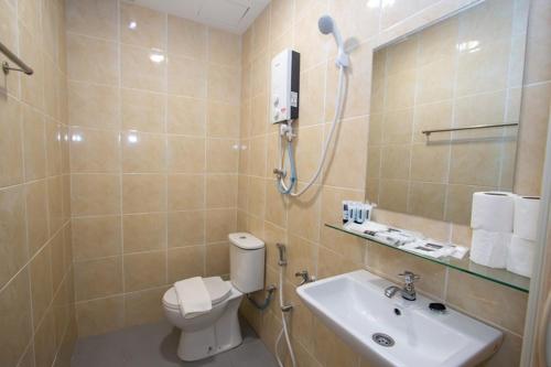 La salle de bains est pourvue de toilettes et d'un lavabo. dans l'établissement Southern Tip Hotel, à Pontian Kecil