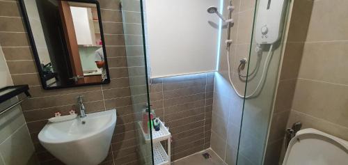 een badkamer met een wastafel, een toilet en een spiegel bij Kozi Square New SGH Cozy Home LV7D in Kuching