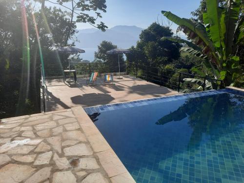 a swimming pool with a view of the mountains at Kit Sasaki Ilhabela in Ilhabela