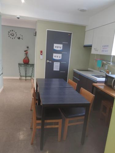 a black table and chairs in a kitchen at T stay pension in Cheongju