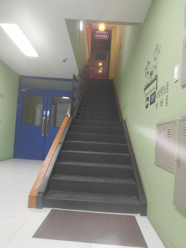a staircase in a building with a blue door at T stay pension in Cheongju