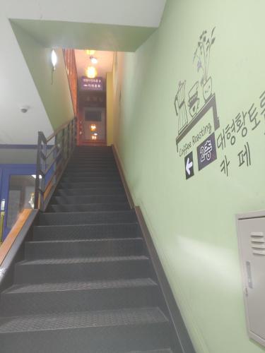 a staircase in a building with a sign on the wall at T stay pension in Cheongju