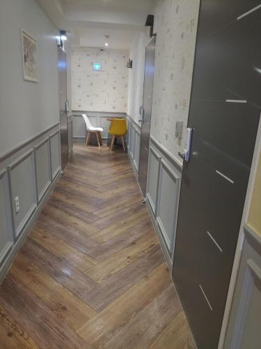 a hallway with a door and a table and chairs at T stay pension in Cheongju