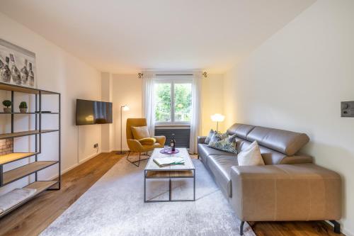 a living room with a leather couch and a table at Chasa Valambrun 1004 in Vulpera