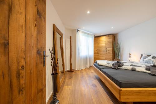 a bedroom with a bed and a wooden wall at Chasa Valambrun 1004 in Vulpera