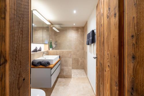 a bathroom with a white sink and a mirror at Chasa Valambrun 1004 in Vulpera