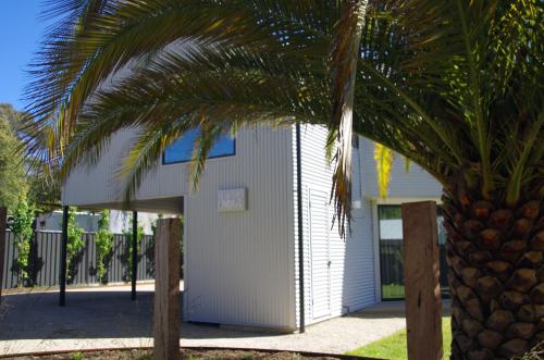 a white building with a palm tree in front of it at John and Jane's Beechworth in Beechworth