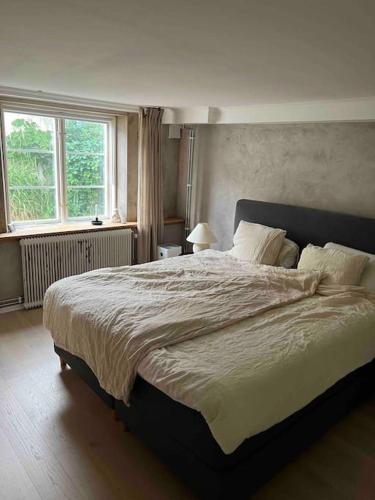 a bedroom with a large bed and a window at Enkelt boende med närhet till centrala Jönköping. in Jönköping