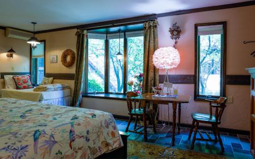 a bedroom with a bed and a table and windows at Stone Chalet Bed & Breakfast Inn in Ann Arbor