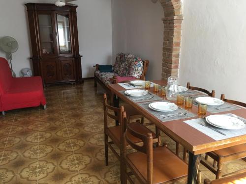 a dining room with a table and a red chair at Casa Roda in Castiglione del Lago