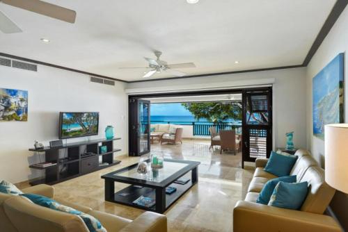 ein Wohnzimmer mit Sofa und Tisch in der Unterkunft Coral Cove 7 - Sunset Blue Sky Luxury in Saint James