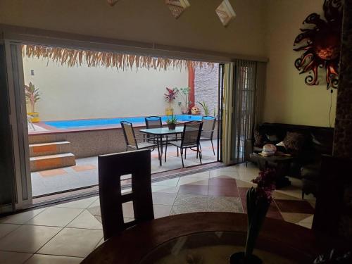 - un salon avec une table, des chaises et une piscine dans l'établissement Casa KOCH, à Manzanillo