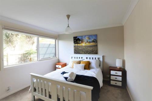 um quarto com uma cama branca e uma janela em Sunderland Escape em Sunset Strip