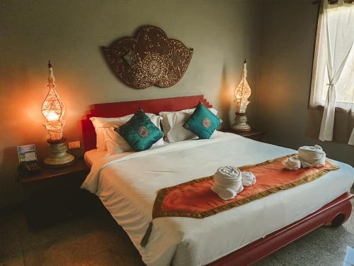 a bedroom with a bed with two lamps on it at Gudi Boutique Hotel in Mae Rim