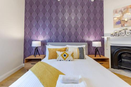 ein Schlafzimmer mit einem großen Bett mit einer lila Wand in der Unterkunft Sydney CBD stylish water view apartment 58 in Sydney