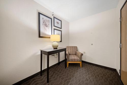 a room with a desk and a chair and a lamp at AmericInn by Wyndham Ames in Ames