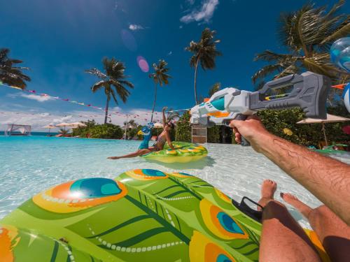 a man is laying on the water at a water park at Sun Siyam Iru Veli - 24 Hours Premium All-Inclusive with Free Transfers in Dhaalu Atoll