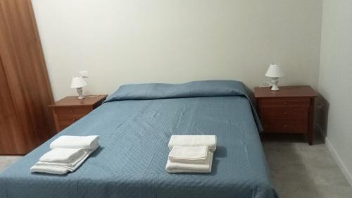 Un dormitorio con una cama azul con toallas. en Alloggio turistico Garibaldi, en Viterbo