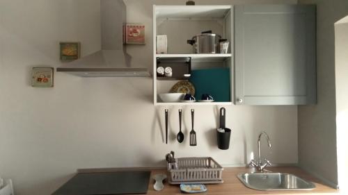 a kitchen with a sink and a cabinet with utensils at Alloggio turistico Garibaldi in Viterbo