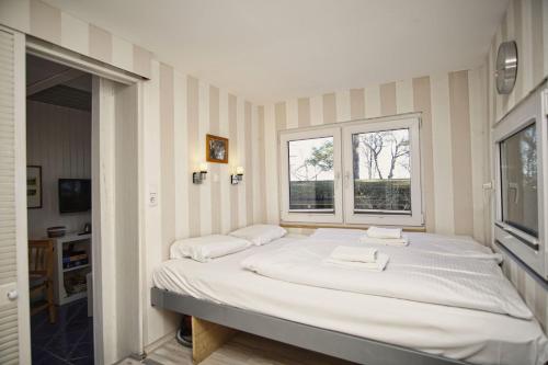 a large bed in a room with a window at Dünenchalet Nr 49 in Göhren