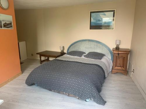 1 dormitorio con cama y mesa de madera en logements vue sur mer ,chambre et cuisine équipée ,accès indépendant, terrasse en Trélévern