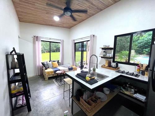 a kitchen with a ceiling fan and a living room at Casa Buena Karma in Ojochal