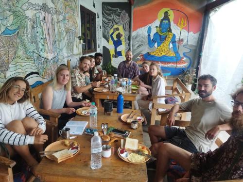 a group of people sitting around a table in a restaurant at Pokhara Youth Hostel in Pokhara