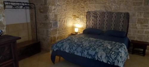 a bedroom with a bed with a blue comforter at INcentro in Bitonto