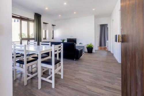 a kitchen and living room with a white table and chairs at Holy Escape in Santa Cruz