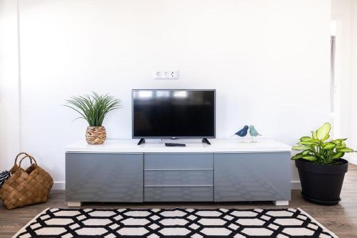 a living room with a tv on a white cabinet at Holy Escape in Santa Cruz
