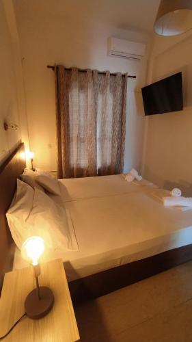 ein Schlafzimmer mit einem Bett und einem Tisch mit einer Lampe in der Unterkunft Perix House in Neos Marmaras