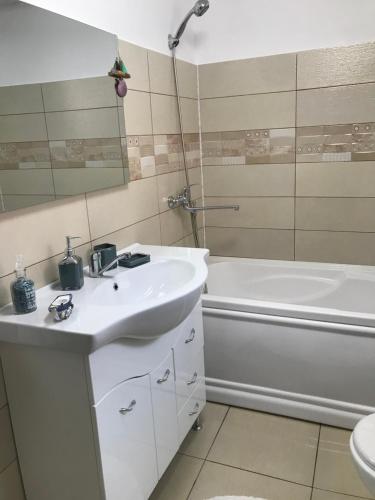a bathroom with a sink and a tub and a toilet at CaSa Stai in Mangalia