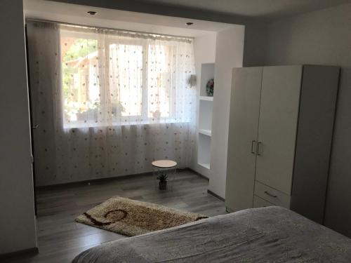 a bedroom with a bed and a window at CaSa Stai in Mangalia