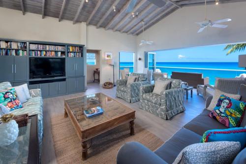 ein Wohnzimmer mit Sofas und Fernseher in der Unterkunft Westshore Beach House by Blue Sky Luxury in Saint James