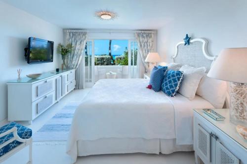 a white bedroom with a white bed and a television at Reeds House 3 by Blue Sky Luxury in Saint James